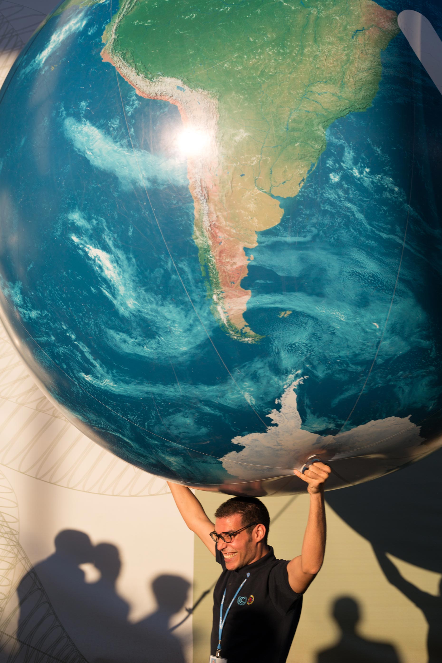 man holding inflatable world globe on shoulders, by Scotland Greenpeace photographer 