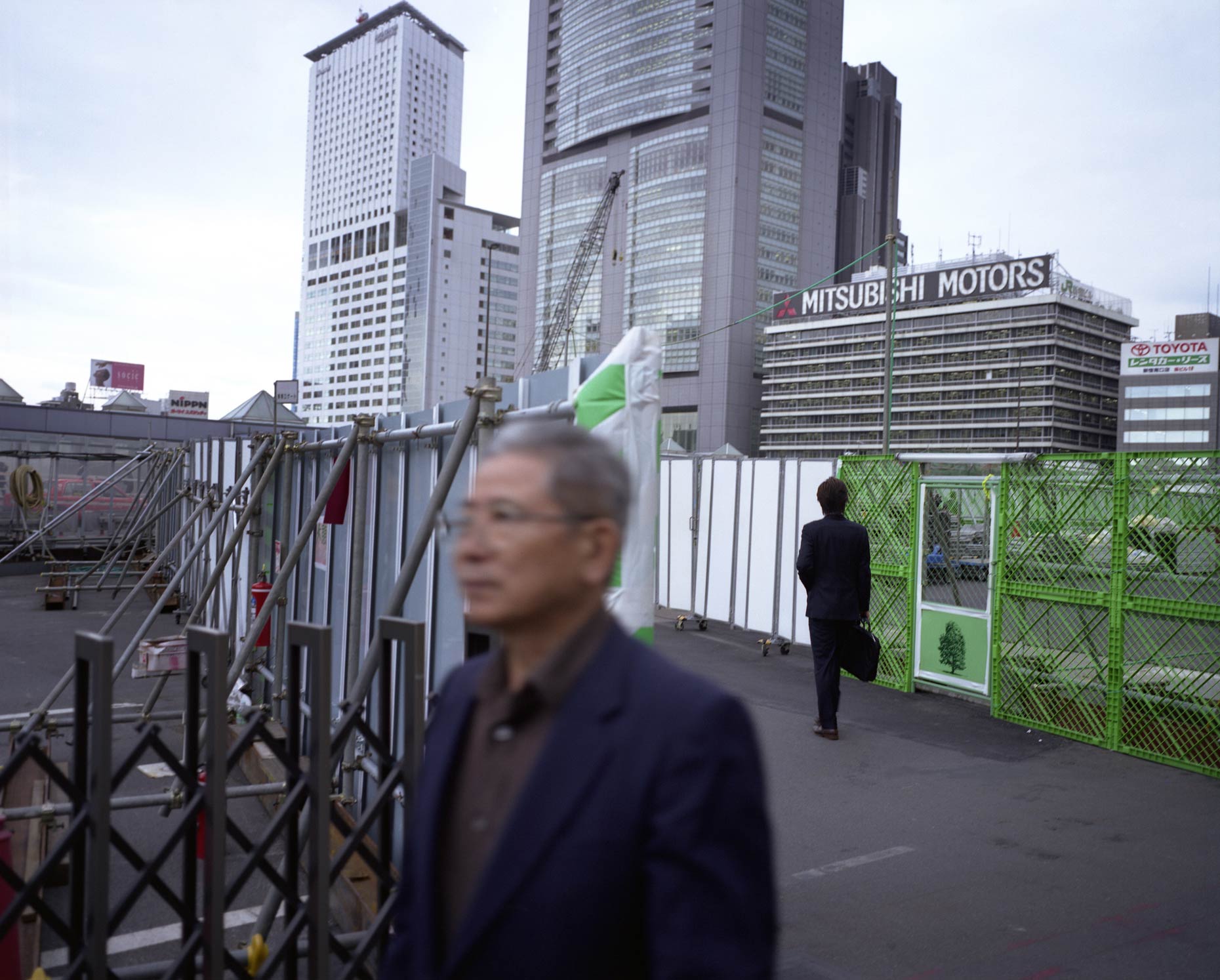 Commuters walk past Billboards depicting nature, Tokyo, Japan.